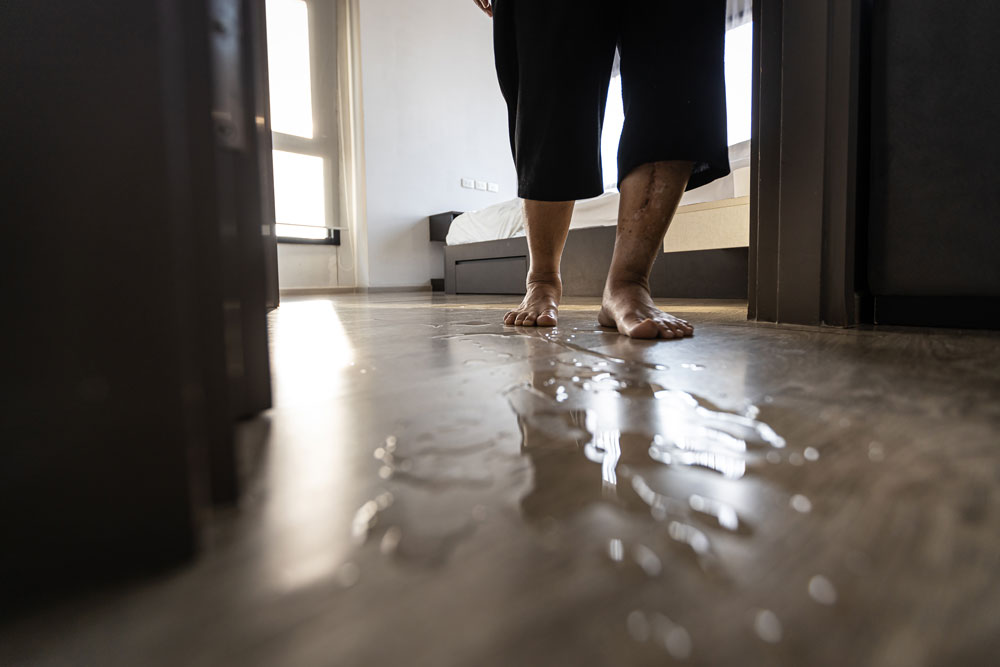 Idoso caminhando sobre um piso molhado e escorregadio em seu quarto.