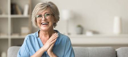 Senhora sorrindo, feliz e em segurança dentro de  sua casa